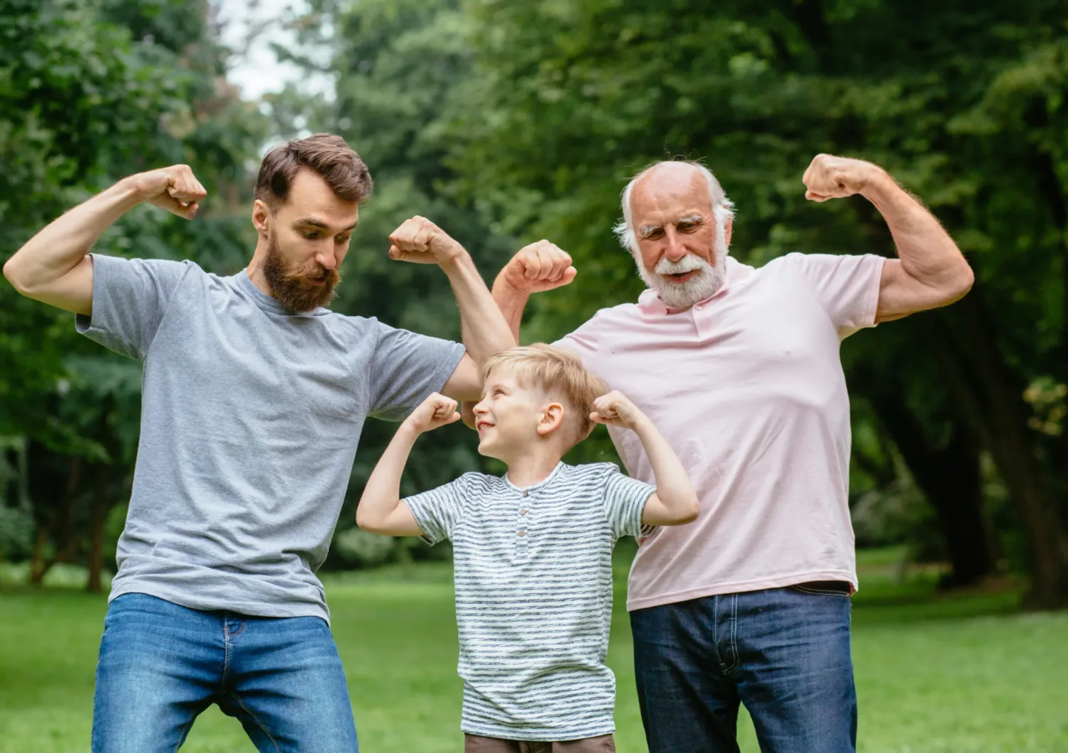 Three generations of Aylo Health patient's showing off their muscles in a park.