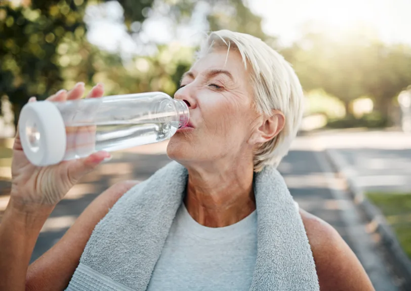 An Aylo Health patient drinking water outside while she's exercising