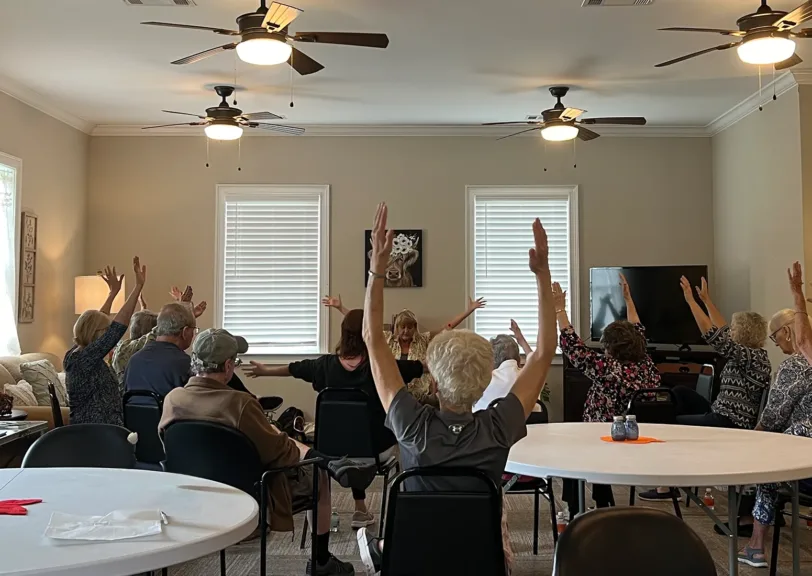 Aylo Health yoga instructor teaches room full of Ball Ground seniors chair yoga